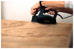Reduce the shelf width by by sawing a piece off one edge and then smooth with a power plane